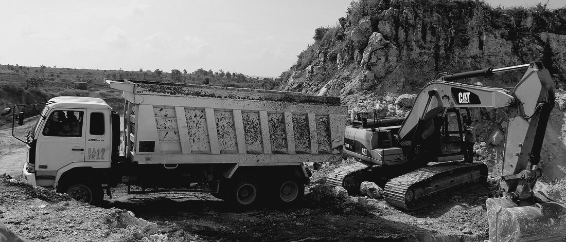 A loaded end dump and excavator working an aggregate pit